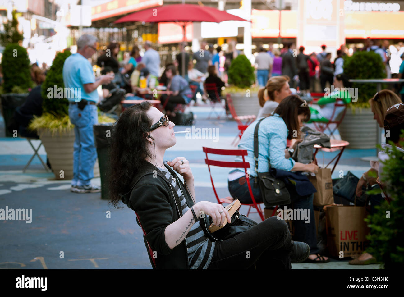 A smoker in a pedestrian plaza in Times Square in New York Stock Photo