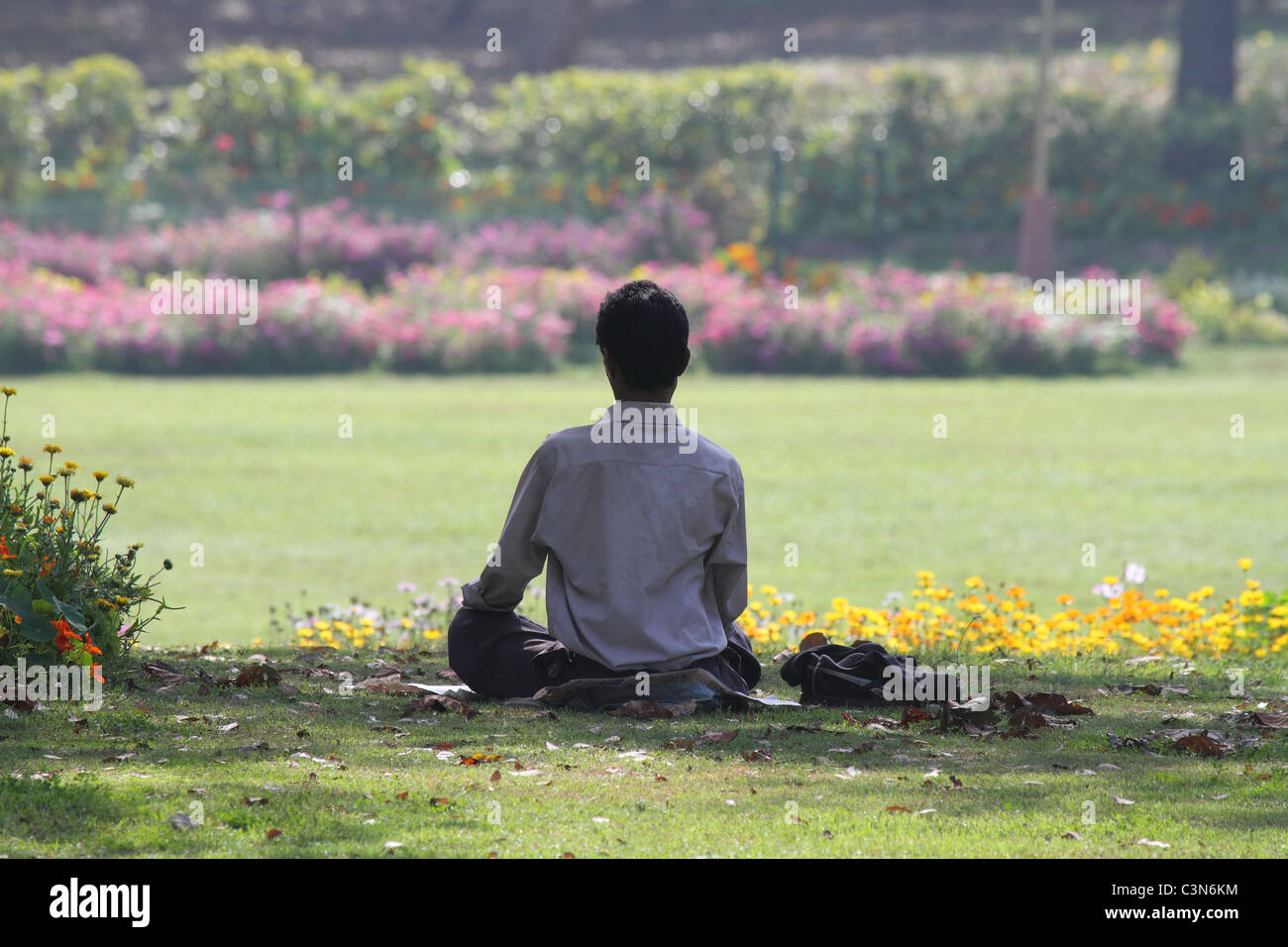 a man meditating in a garden Stock Photo