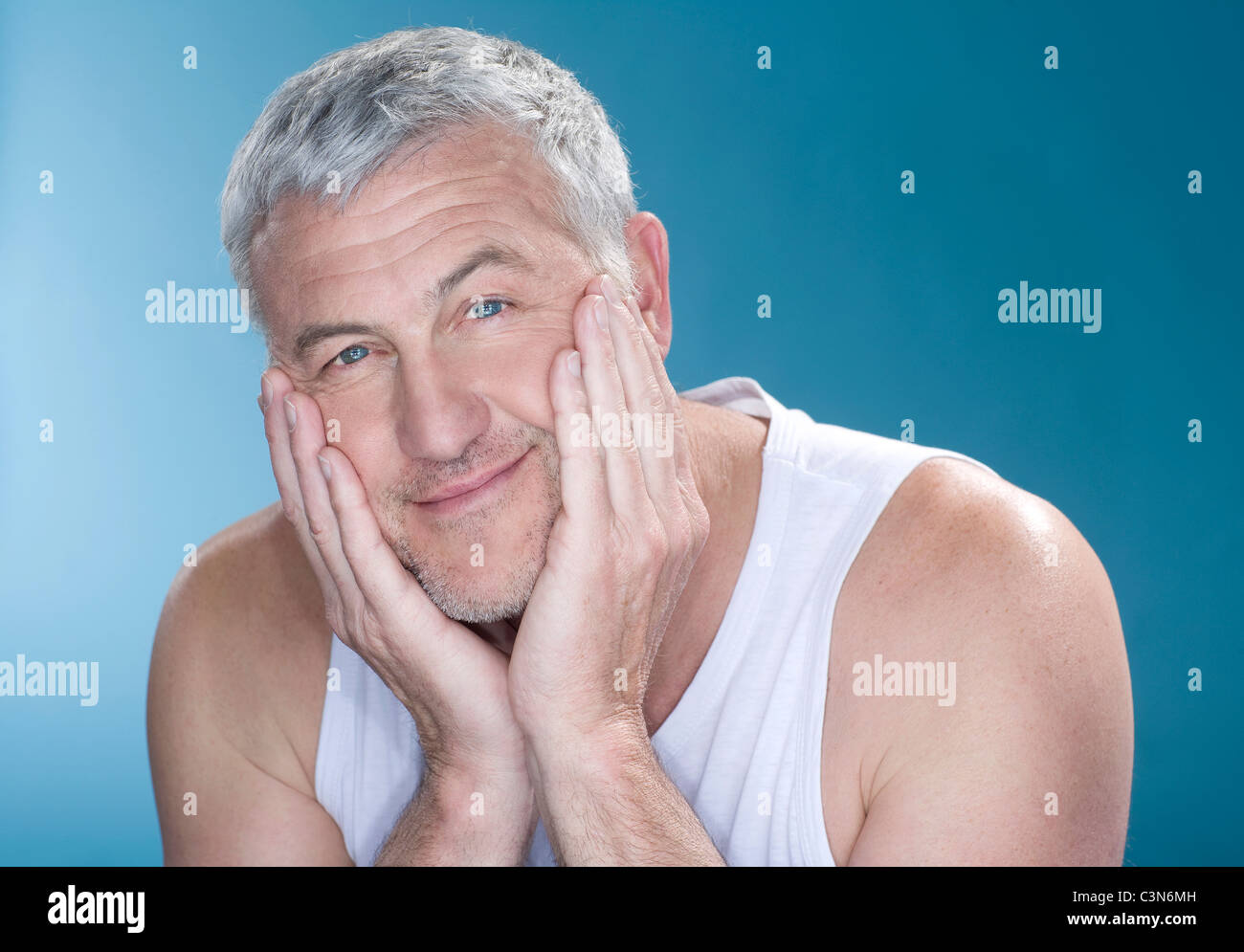 Grey hair man with hands to face happy Stock Photo