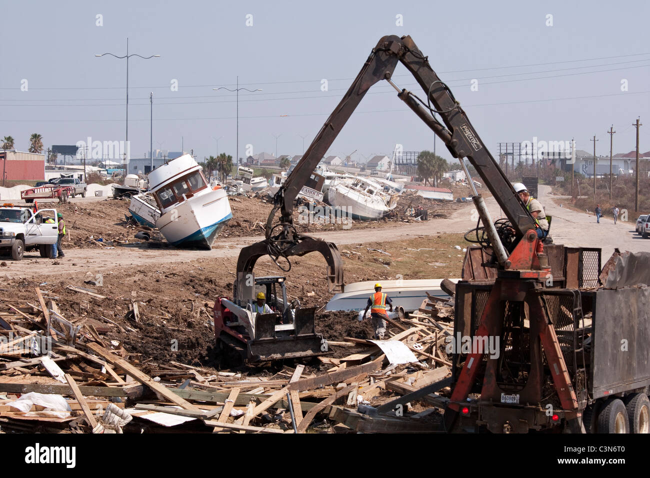 Crane lifting debris from pile of destruction left by category 4 hurricane Ike in Galveston, Texas in September 2008 Stock Photo