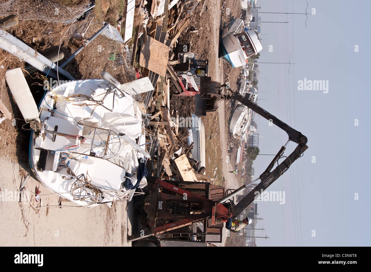 Crane lifting debris from pile of destruction left by category 4 hurricane Ike in Galveston, Texas in September 2008 Stock Photo