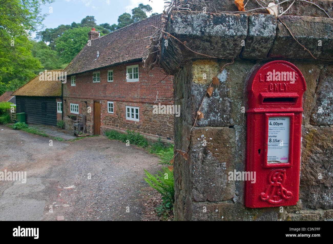 Red letter box, in wall of mill cottage, Friday Street, Surrey, England. Dates from Edward the Seventh Stock Photo
