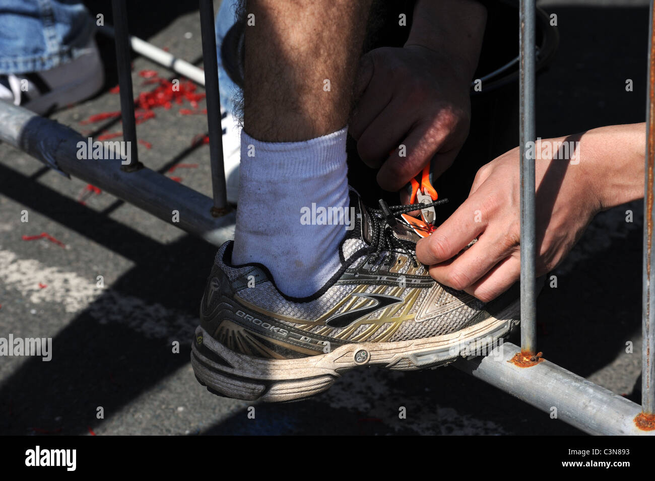 Brighton Marathon 2011 - A runner has the timing chip removed from his trainer after finishing Stock Photo