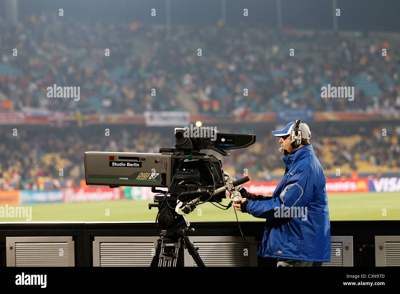 A television camera and operator positioned behind an end line at Royal Bafokeng Stadium in Rustenburg, South Africa - World Cup Stock Photo