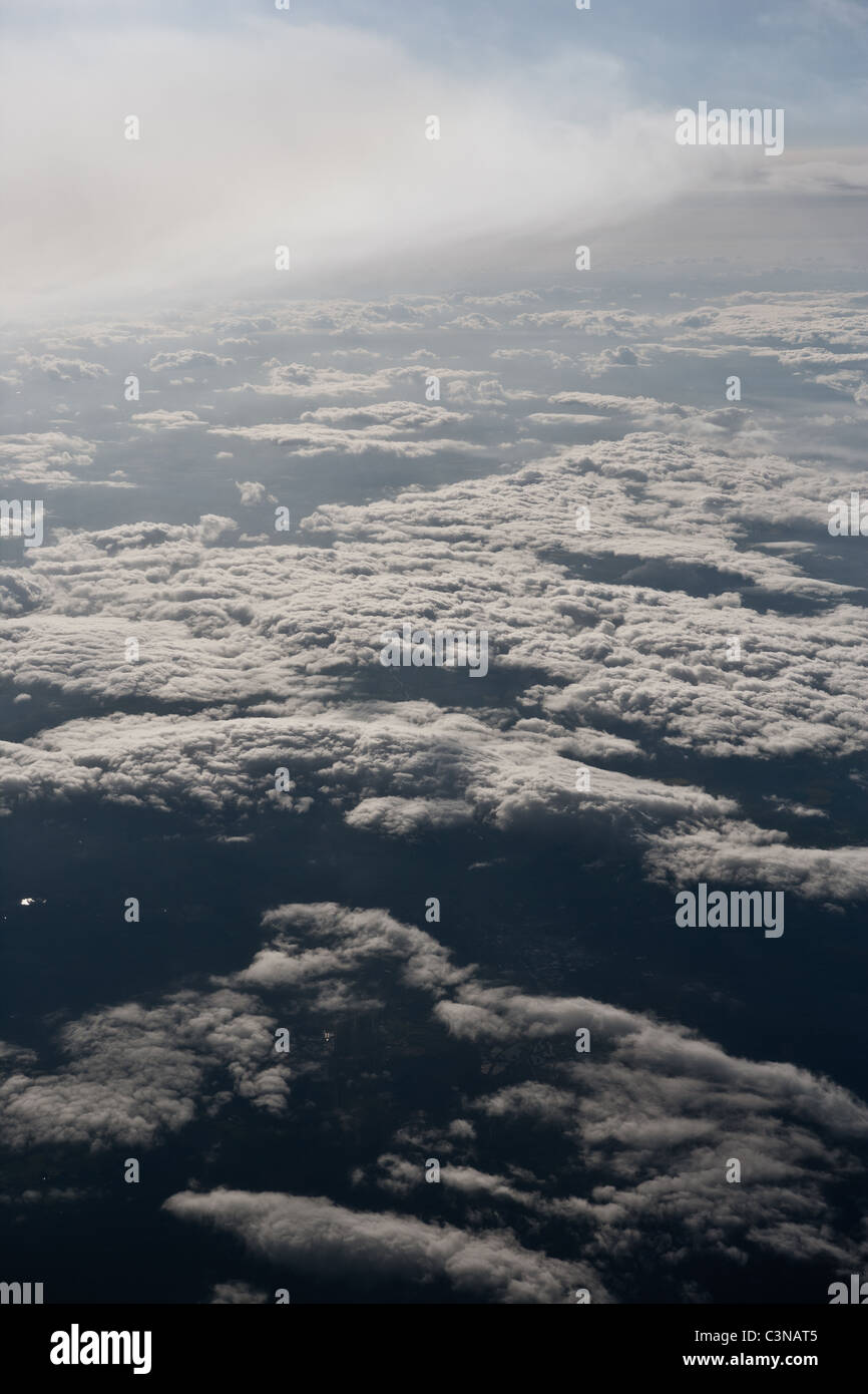 Stratified view of atmosphere. Overhead view of lower Cumulus Mediocris cloud bank  and higher altitude Altostratus clouds. Stock Photo