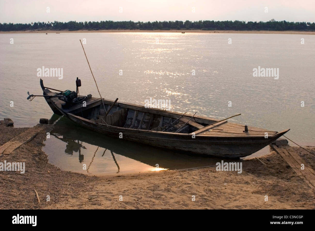 An old rundown wooden fishing boat is tied-up on the shore of the ...