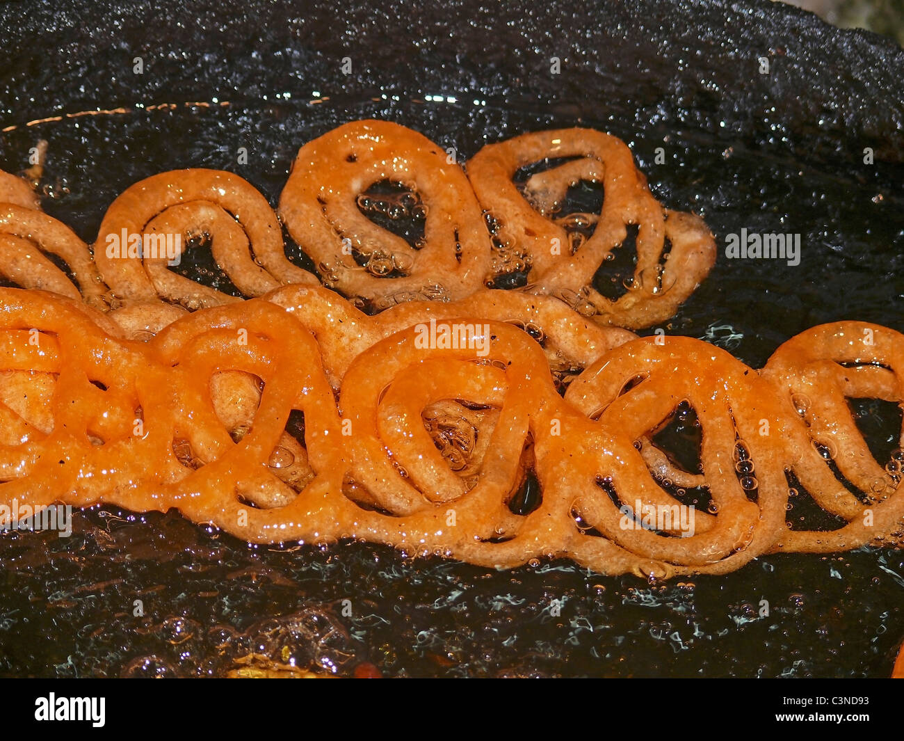 Sweet dish , jalebi yellow color circle deep in sugar water, India Stock Photo