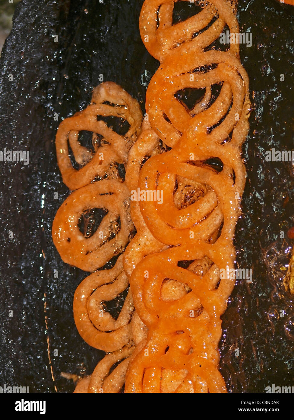 Sweet dish , jalebi yellow color circle deep in sugar water, India Stock Photo