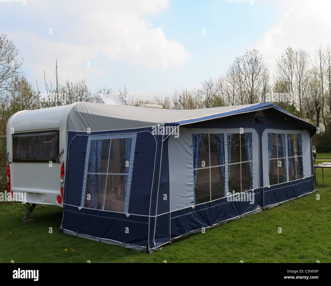 long trailer caravan with awning tent with blue curtains Stock Photo - Alamy