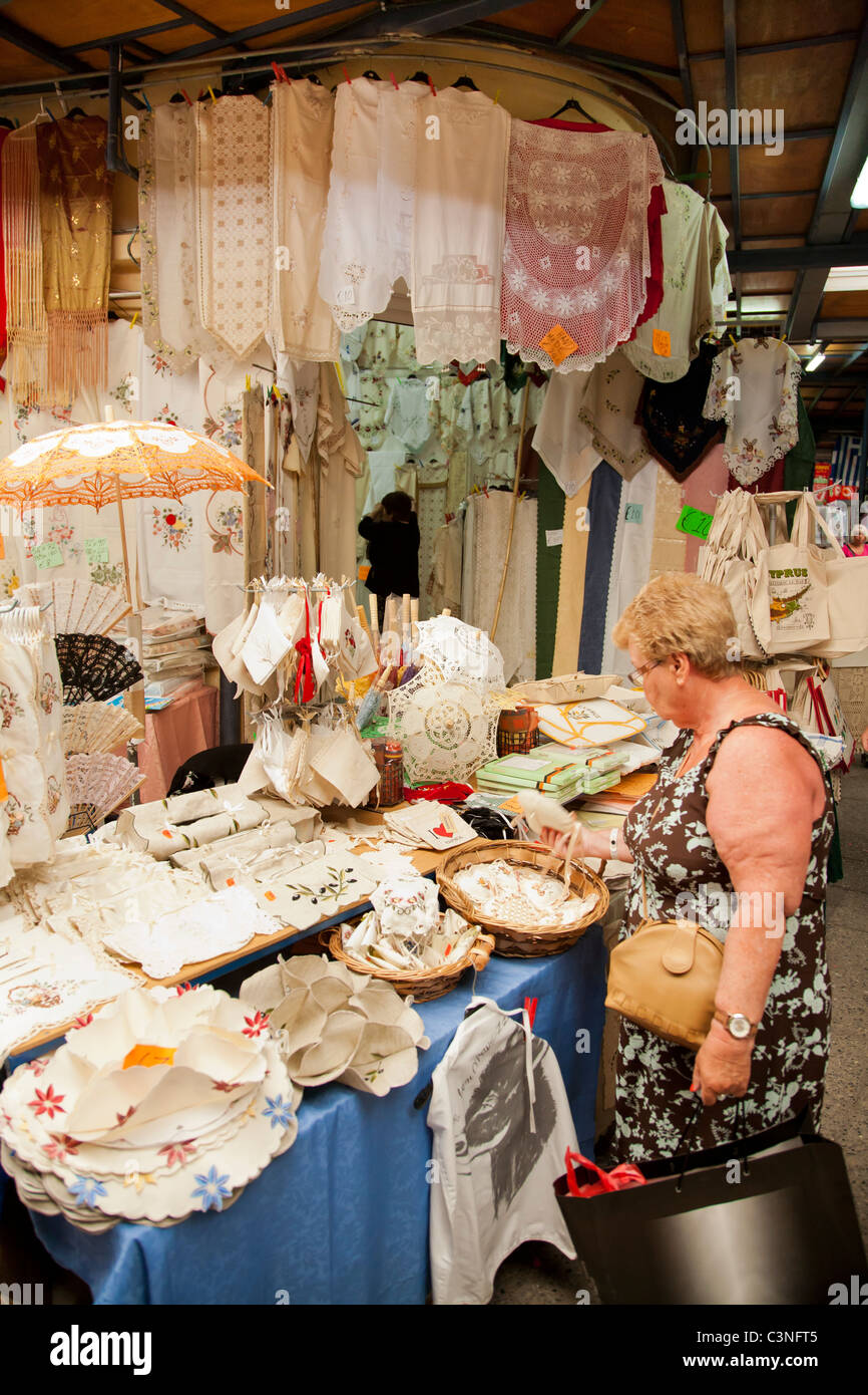Woman browsing a lace stall at the market in Paphos old town, Cyprus Stock Photo