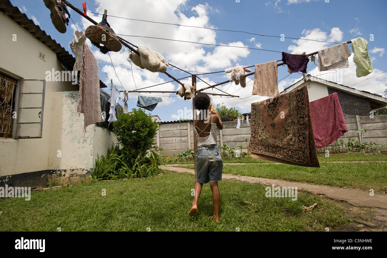A young girl hanging out the washing. Stock Photo