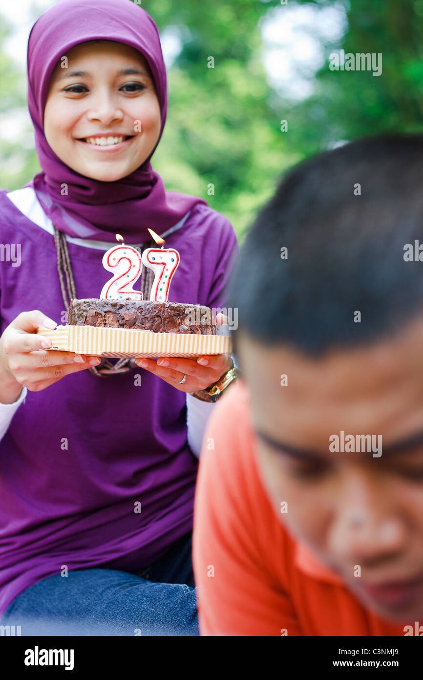 Woman give birthday cake to a man. Stock Photo