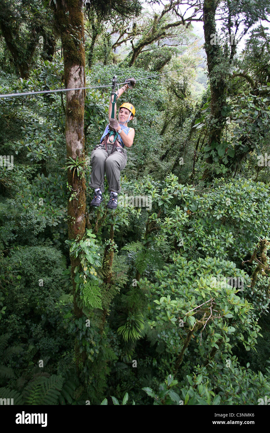 Tourist enjoying canopy experience, with canopy tour operator. Santa