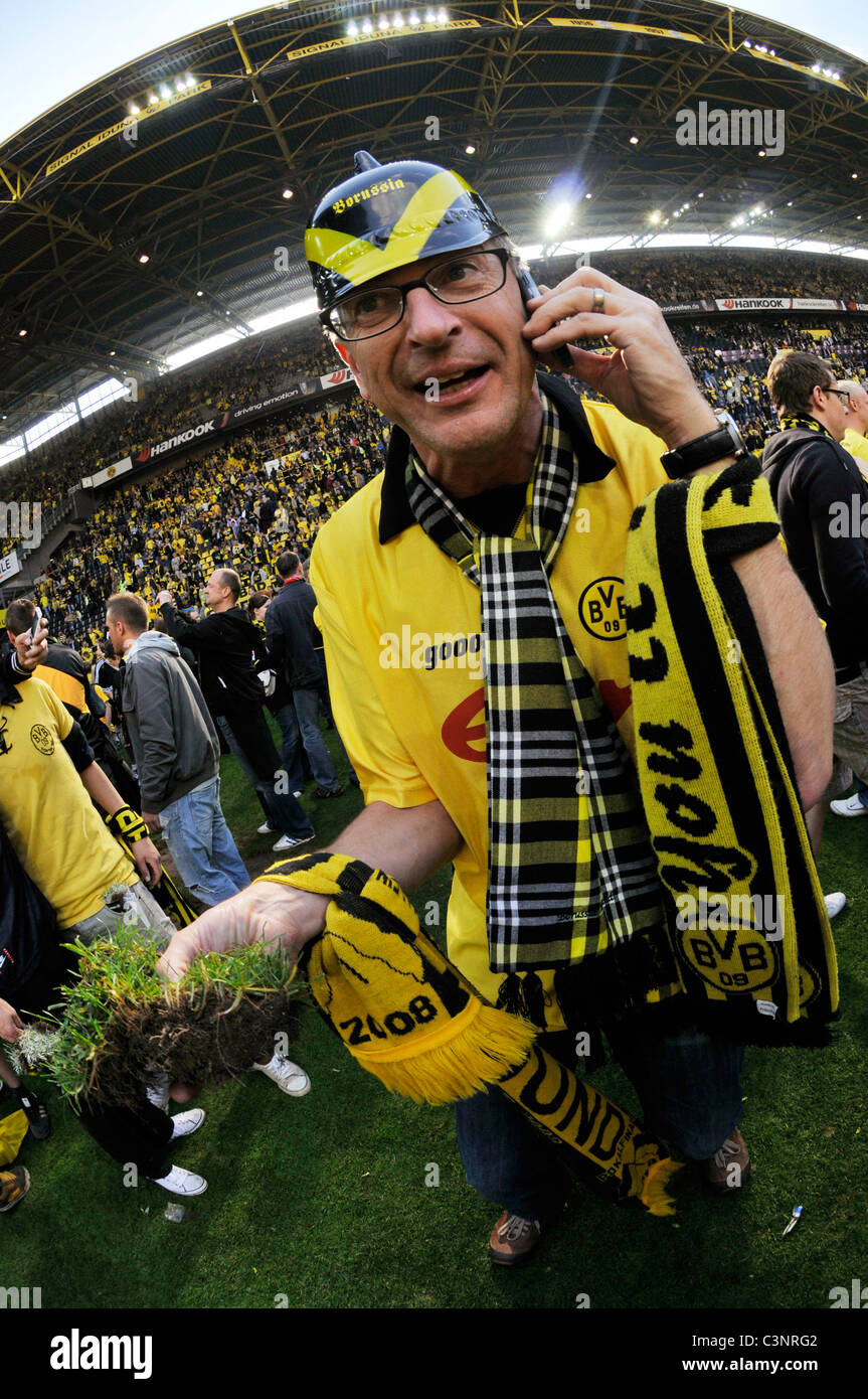 Fans of german football club Borussia Dortmund have flooded the pitch to celebrate their clubs championship title Stock Photo