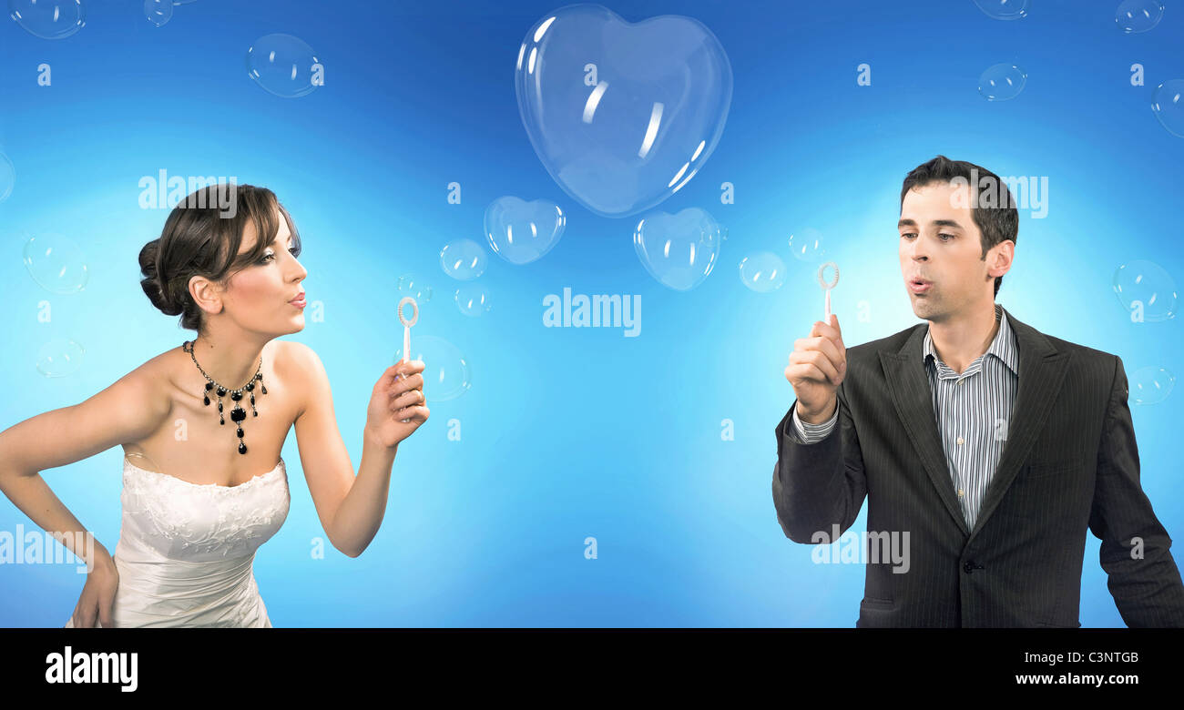 Wedding couple blowing heart shaped romantic soap bubbles Stock Photo