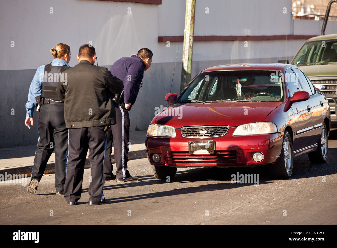 Juarez police look into a car where the driver was shot dead moments earlier in the drug wars