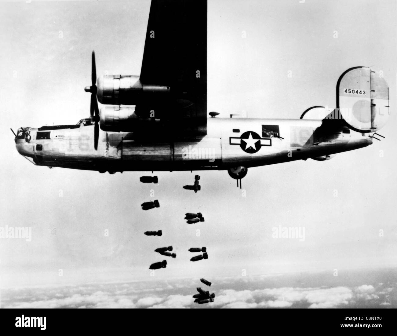 A consolidated B-24 Liberator of the 15th A.F. releases its bombs on the railyards at Muhldorf, Germany on 19 March 1945. Stock Photo