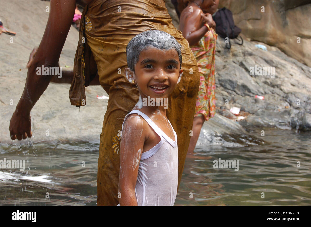 A girl washing at Rawana falls. Ella falls. (Ravana) Stock Photo