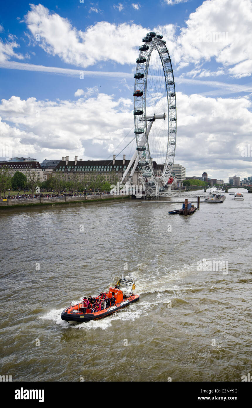 London Eye and Boat with tourists on the Thames River Stock Photo