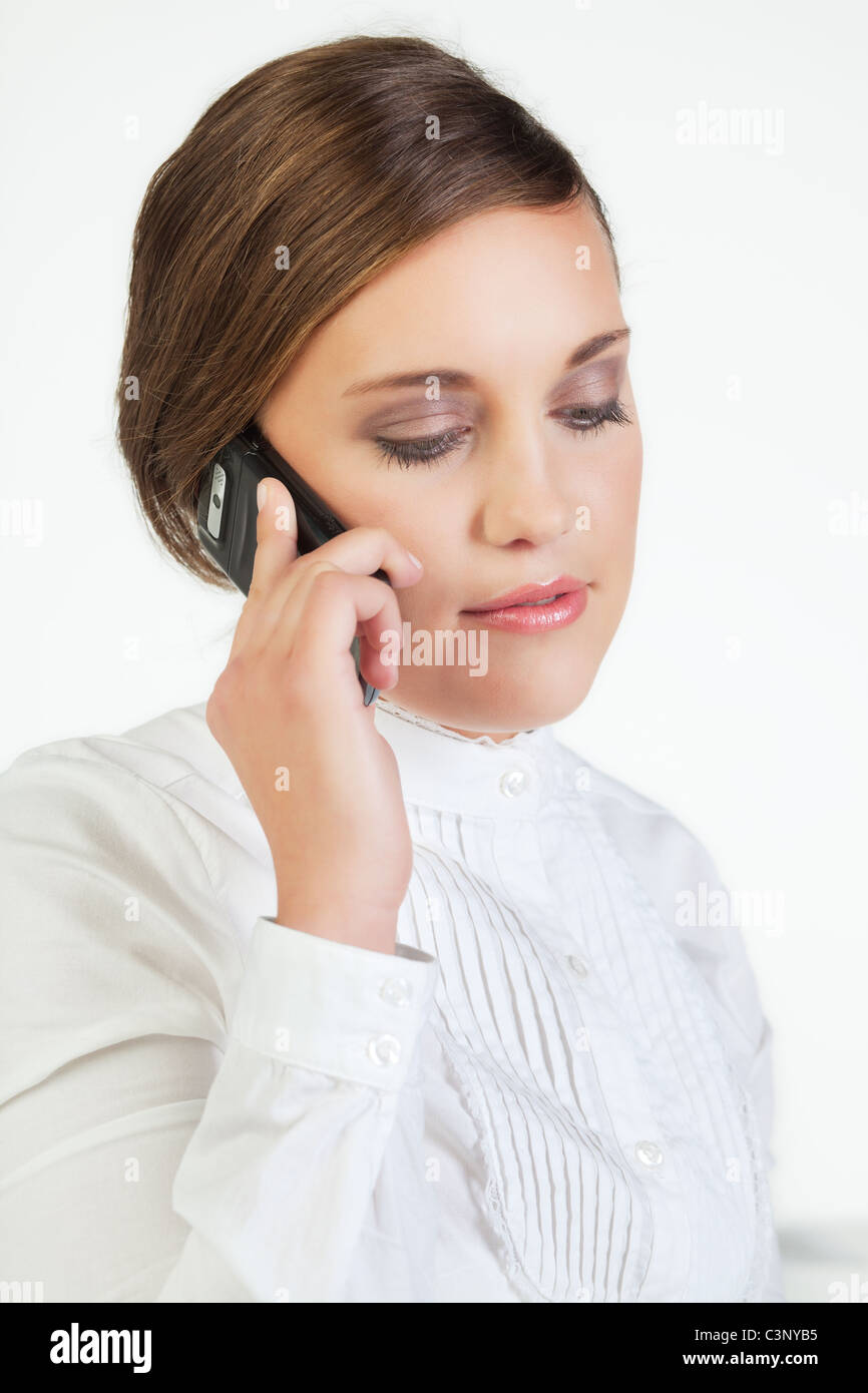 Head portrait of young smiling businesswoman talking on cellphone Stock Photo