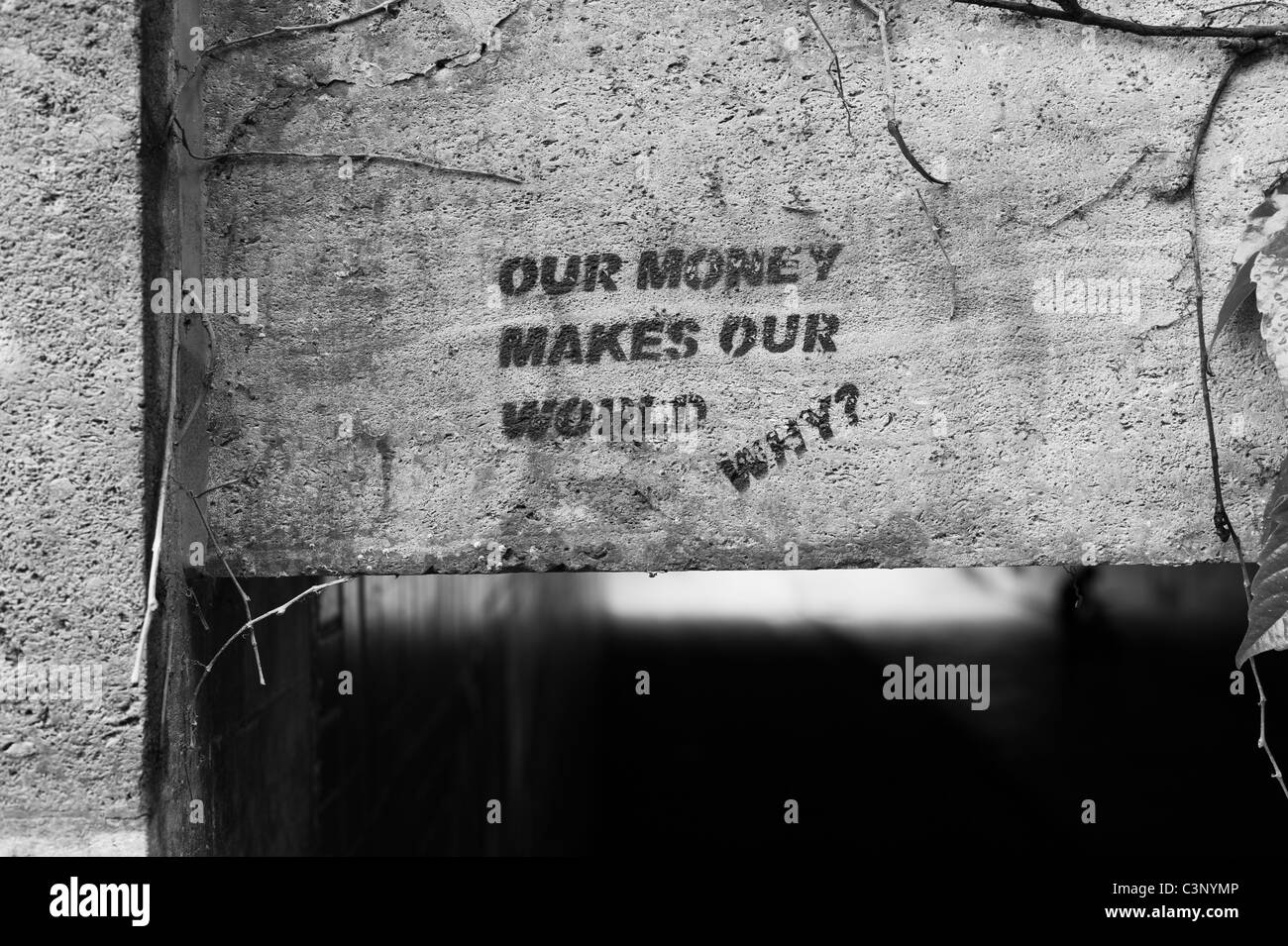 Stencil sprayed onto the stone of the Reichenbachbrücke in Munich showing the words 'Our money makes our world ...Why?', Germany Stock Photo