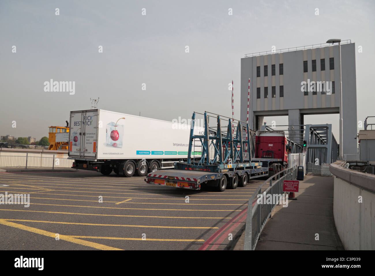 Lorries going down the south bank loading ramp onto the Woolwich Ferry, River Thames, London, UK. Stock Photo