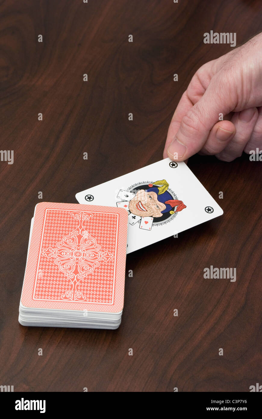 picking up a joker card in a pack of cards Stock Photo