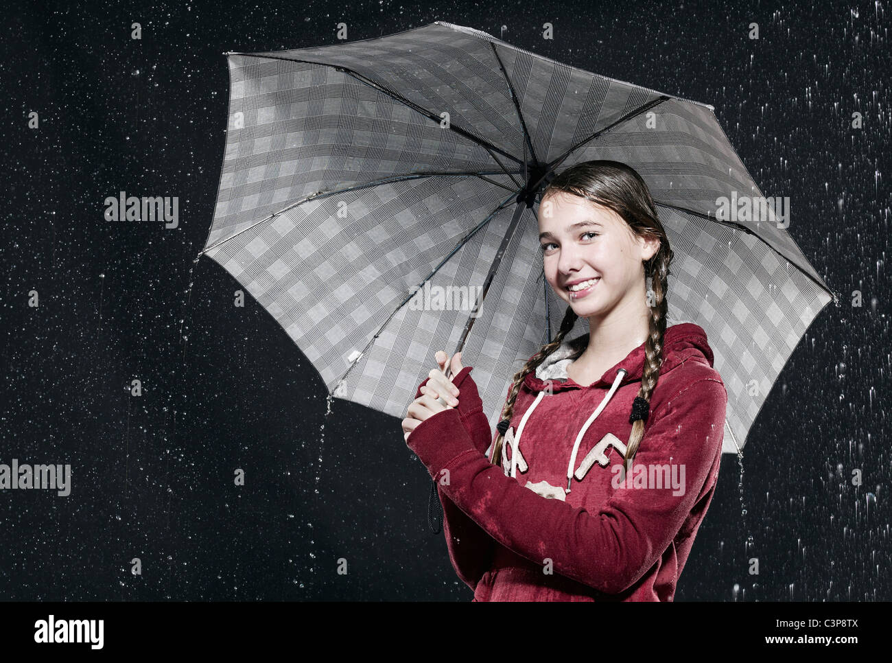 Girl standing in rain, holding umbrella Stock Photo Alamy