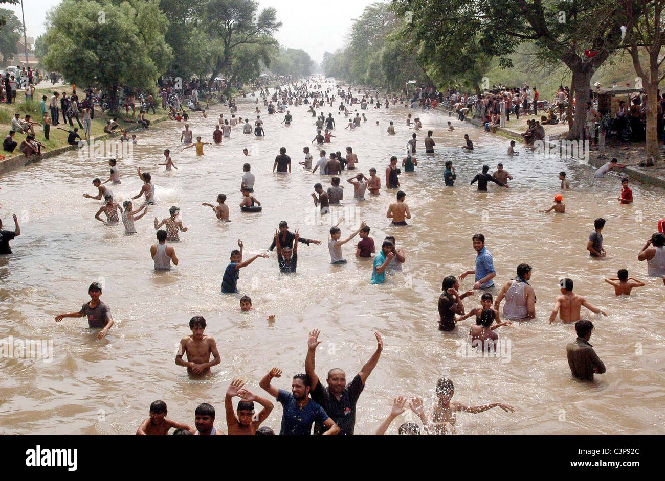 A large number of youths and children enjoy bath to beat the heat at BRB Canal due to hot day of summer season in Lahore Stock Photo