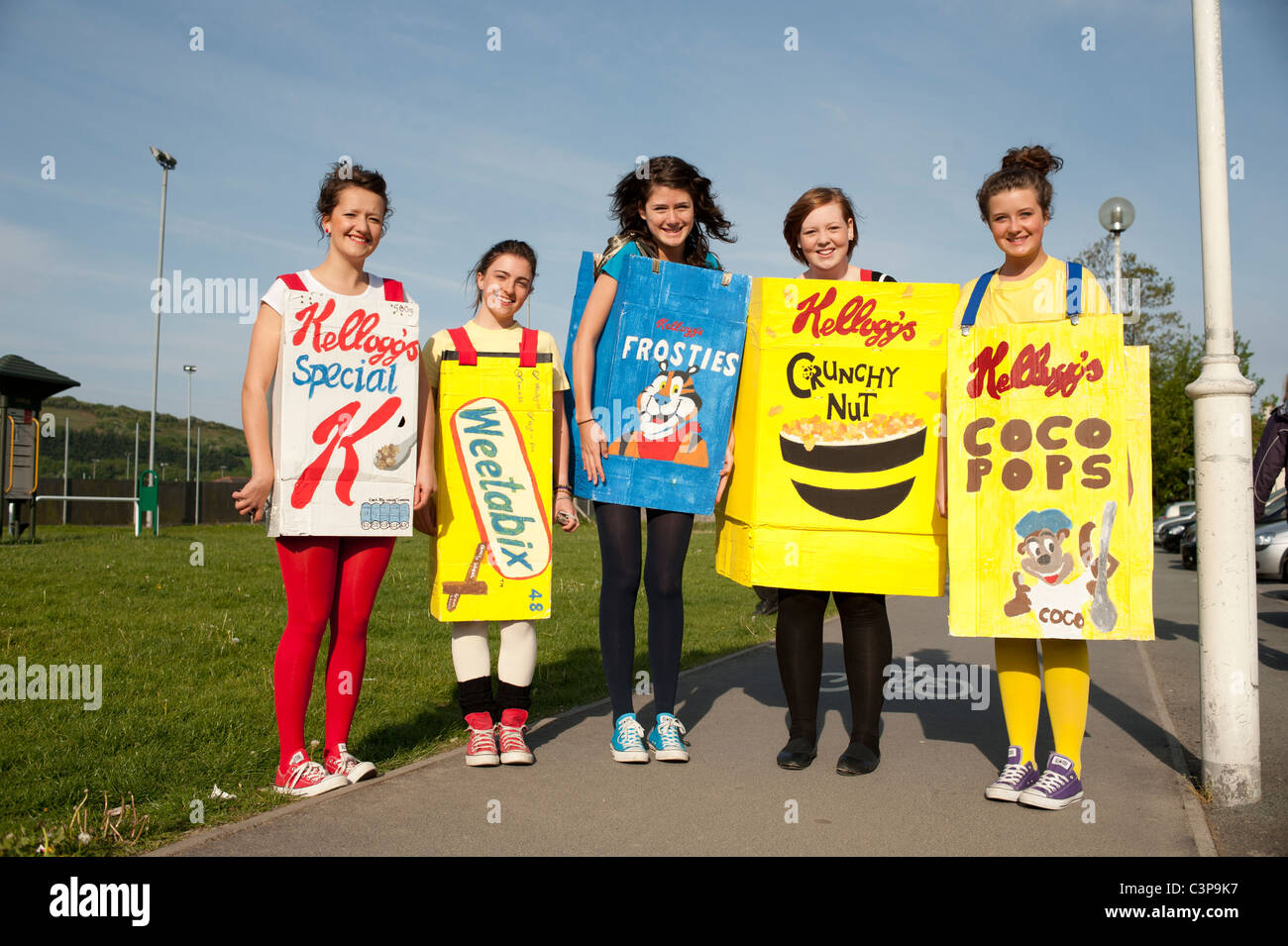 Five teenage girls dressed in fancy dress as packets of breakfast cereals on their last day of school, UK Stock Photo