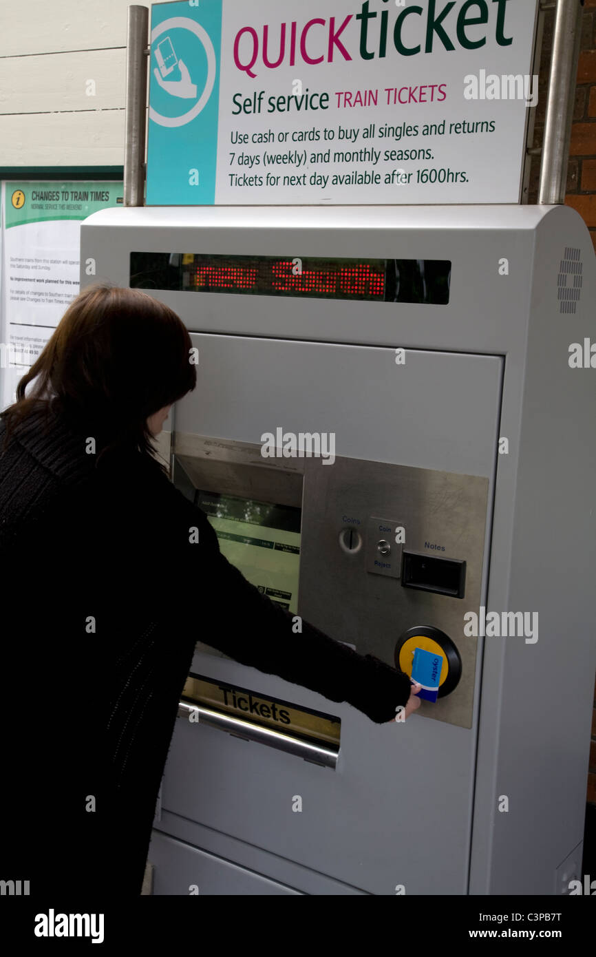 teenage girl using ticket machine at railway station cheam surrey england Stock Photo