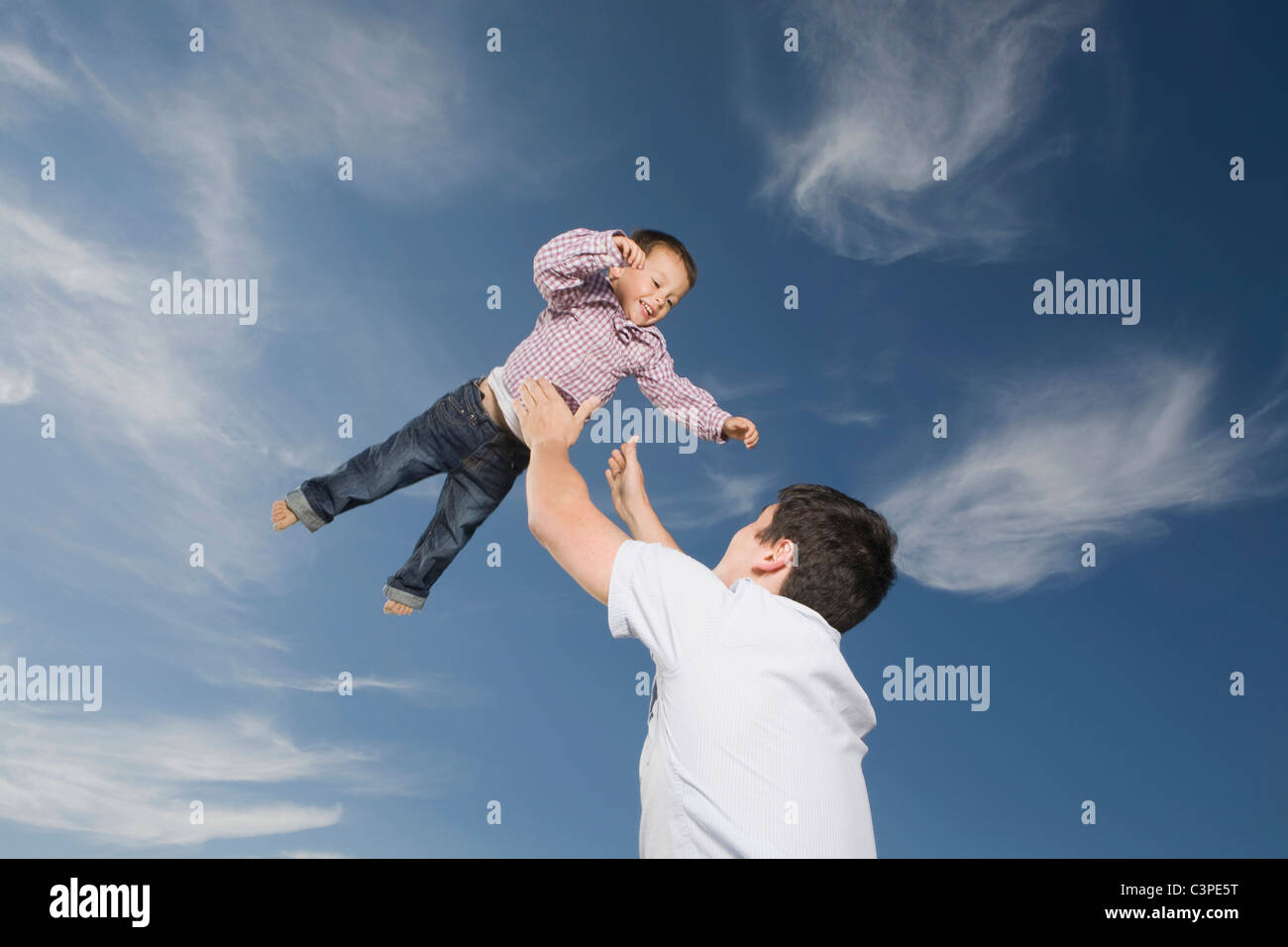 Germany, Schleswig Holstein, Amrum, Father lifting son (3-4) in the air, portrait Stock Photo