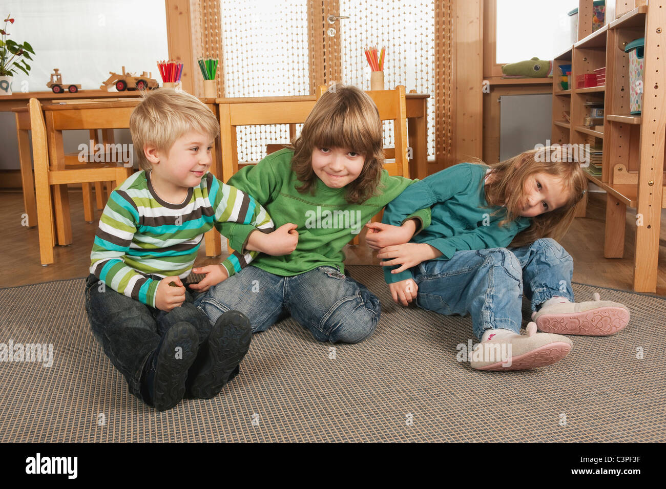 Sitting on the floor with group of children in kindergarten hi-res ...