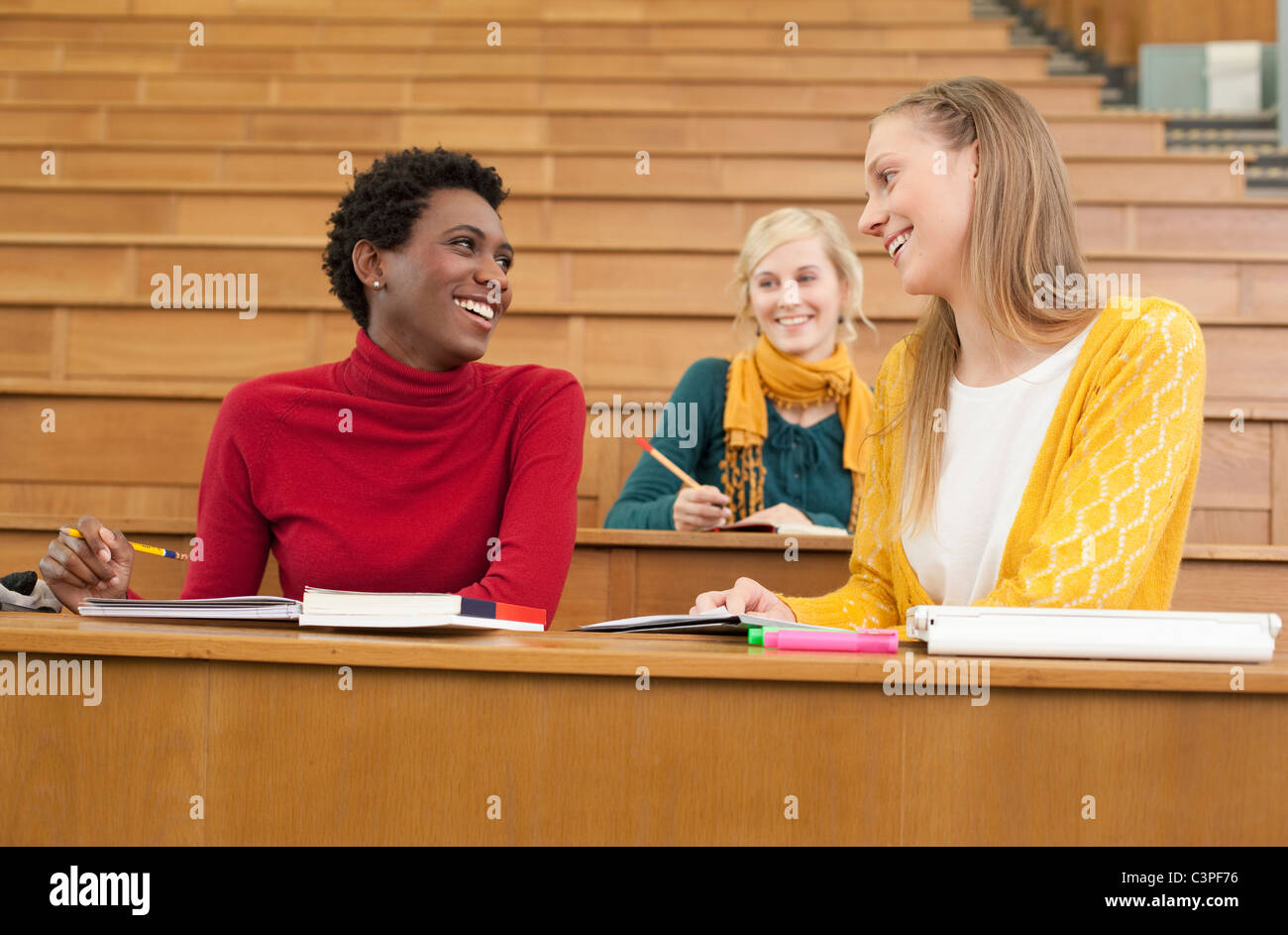 Germany, Leipzig, Students sitting and studying in auditorium, smiling Stock Photo
