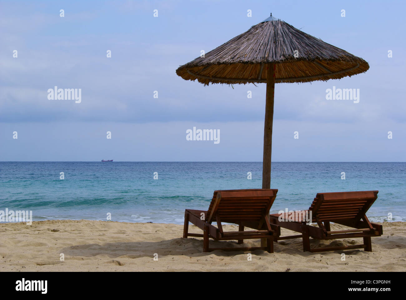 Beach beds and a umbrella at the sunny beach Stock Photo