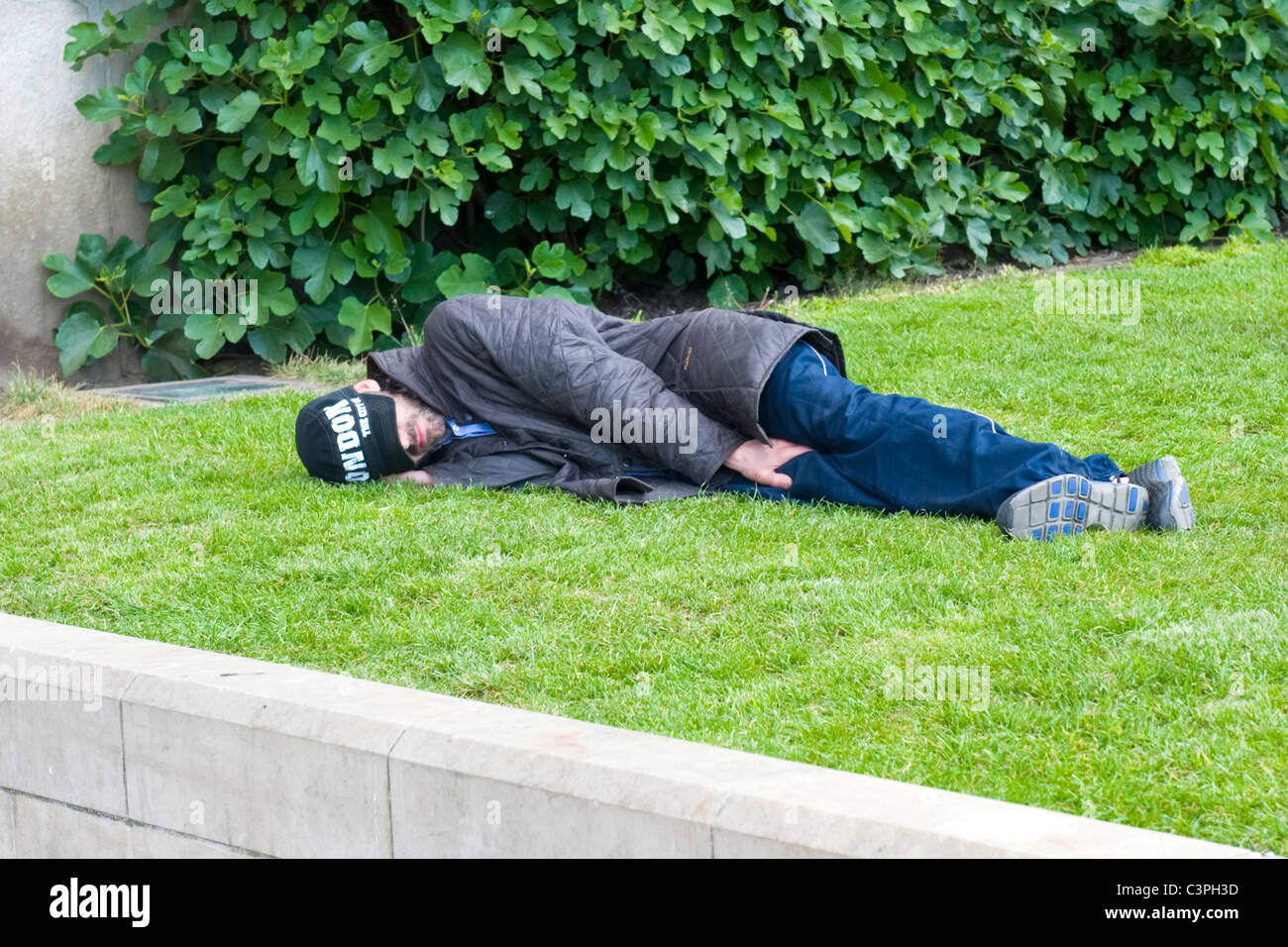 London , Westminster , National Gallery , young man sleeping on lawn of National Gallery homeless vagrant tramp hobo tourist ? Stock Photo