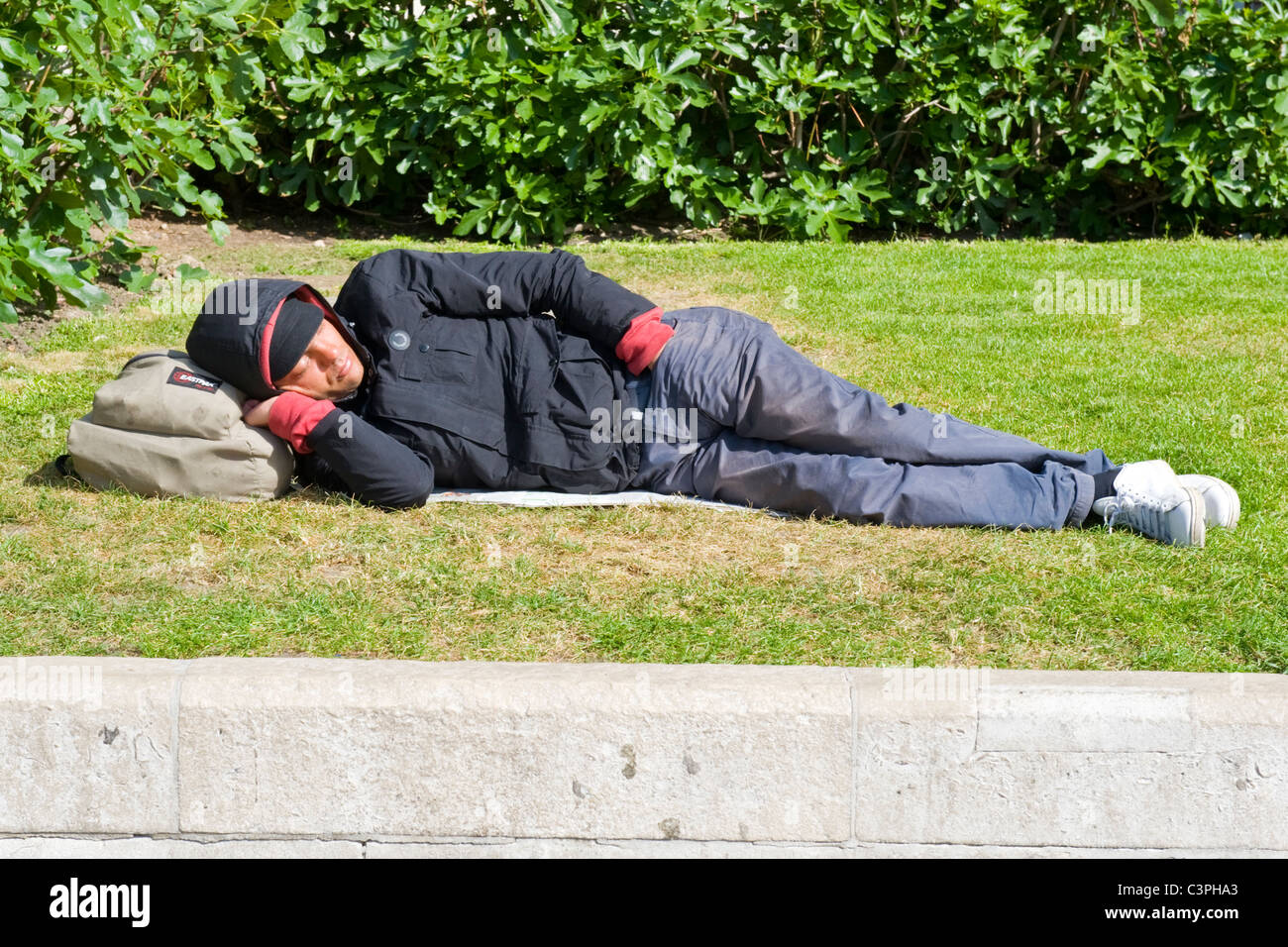 London , Westminster , Trafalgar Square , young man sleeping on lawn of National Gallery homeless vagrant tramp hobo tourist ? Stock Photo