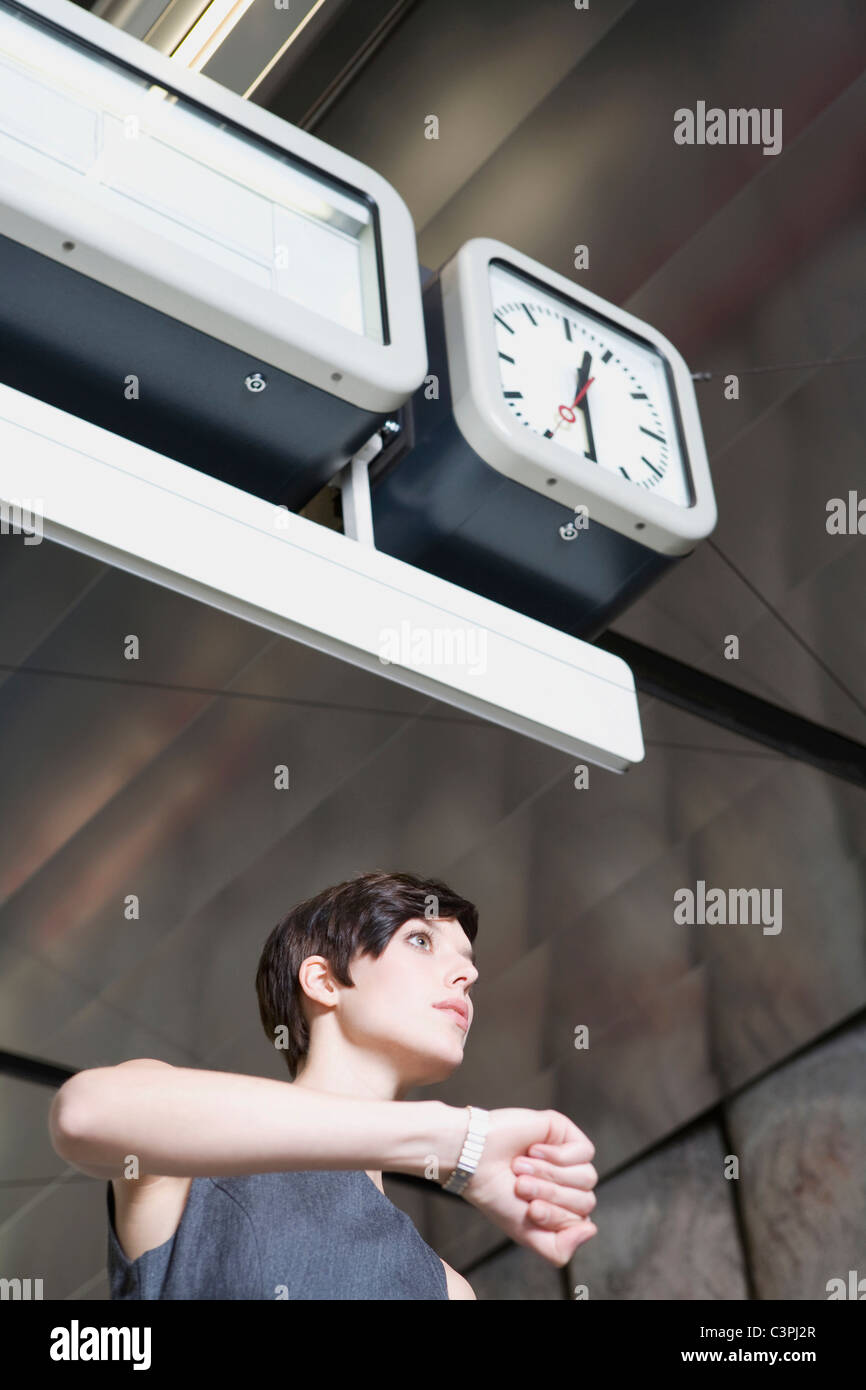 Germany, Bavaria, Munich, Business woman at subway station looking at wrist watch Stock Photo