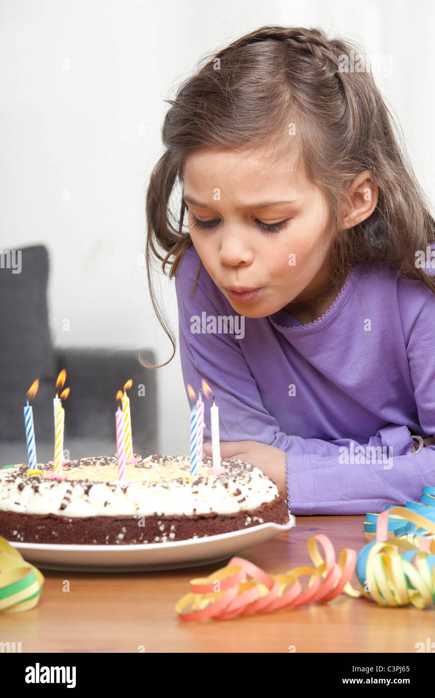 Girl (67) blowing out candles on birthday cake Stock Photo Alamy