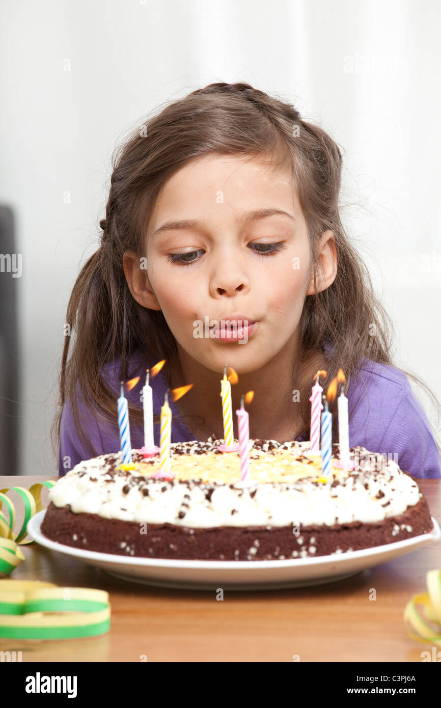 Girl (67) blowing out candles on birthday cake Stock Photo Alamy