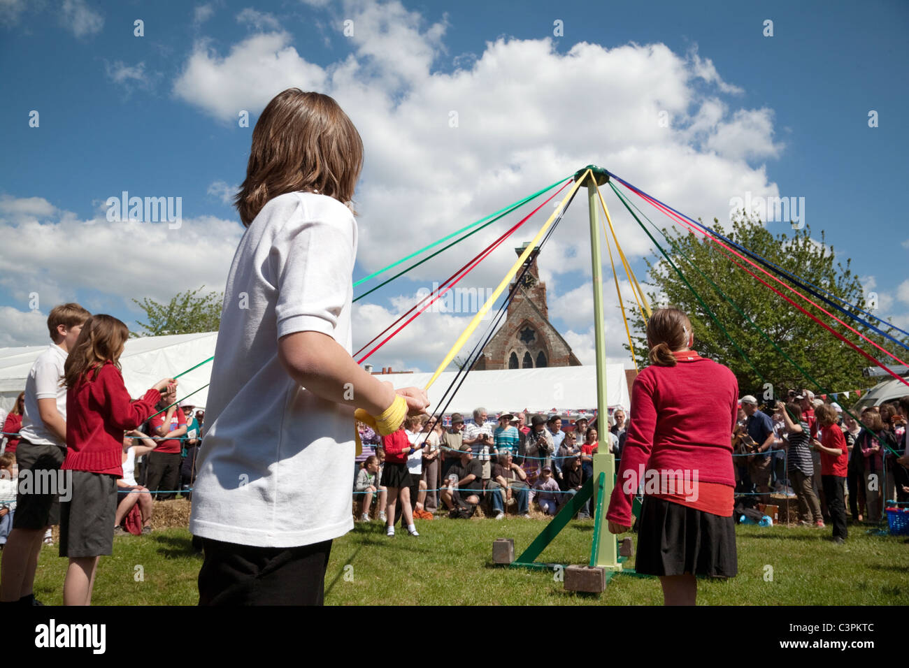 Children from a local primary school dancing round the maypole on May Day at Reach Fair, Reach, Cambridgeshire, UK Stock Photo