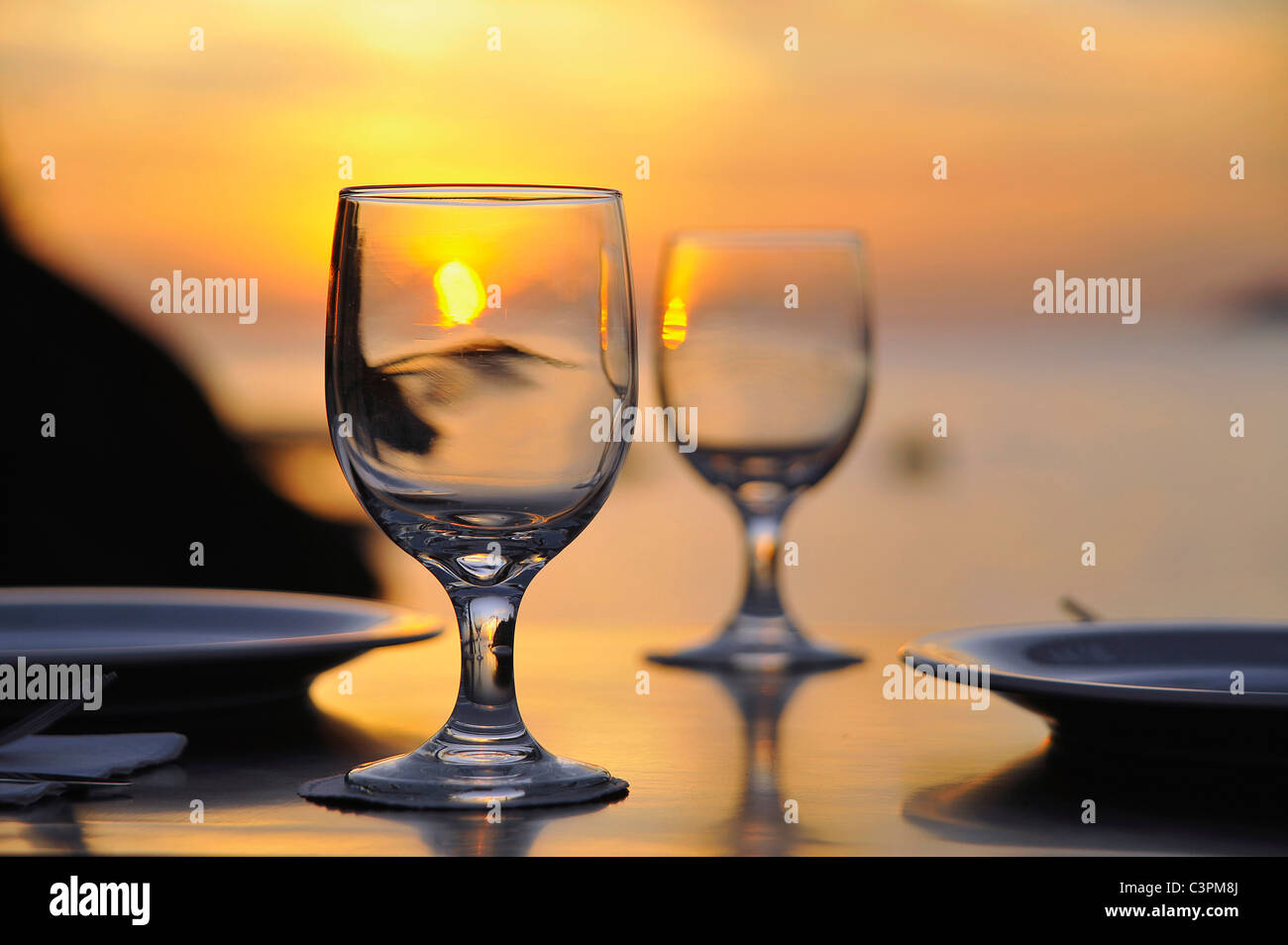 Wine glasses on table at sunset, close-up Stock Photo