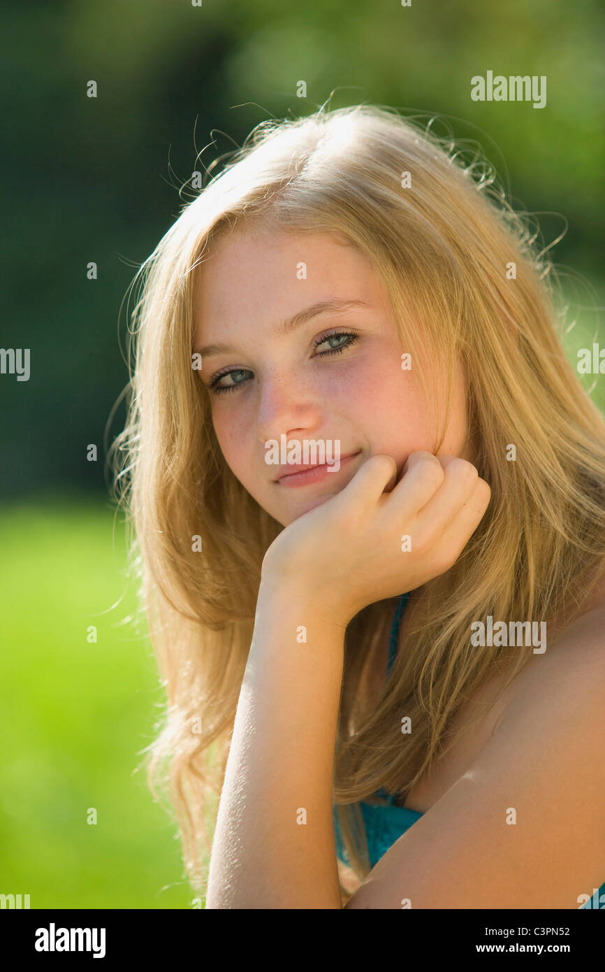 Austria, Teenage girl on track showing her muscles, smiling, portrait stock  photo