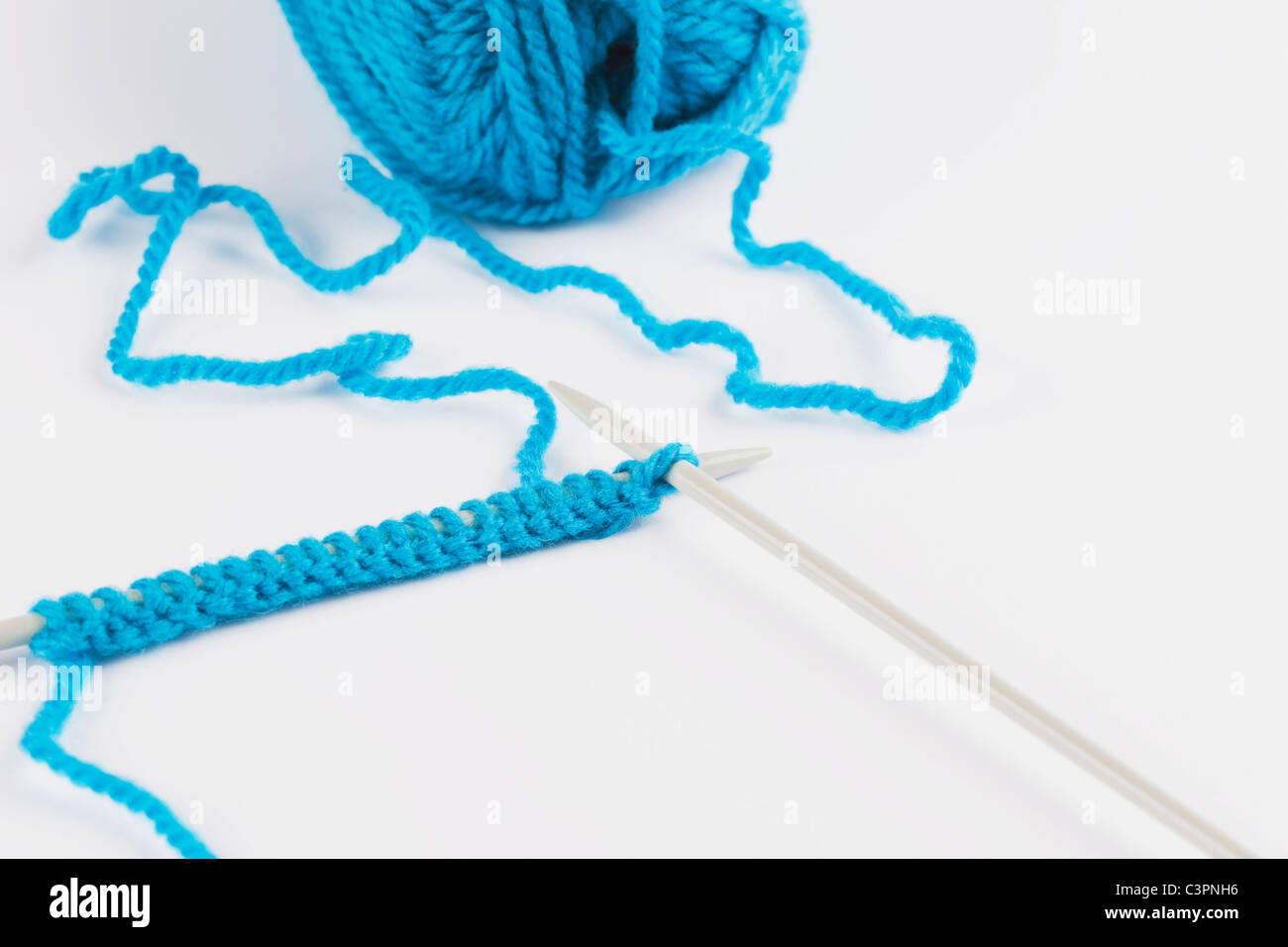 Blue knitting wool and knitting needles on white background Stock Photo ...