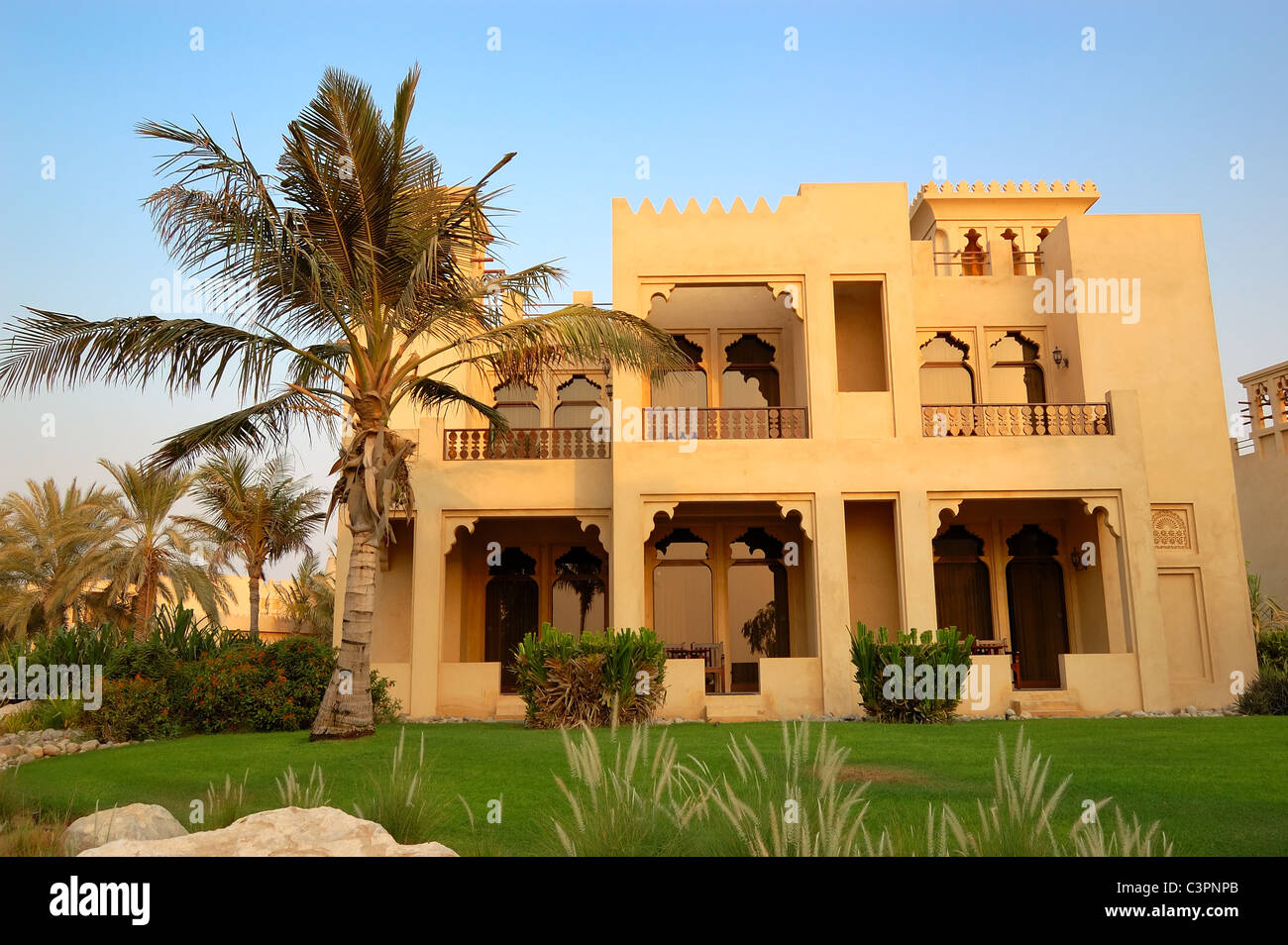 The Arabic style villa and palm during sunset at luxury hotel, Dubai, UAE Stock Photo