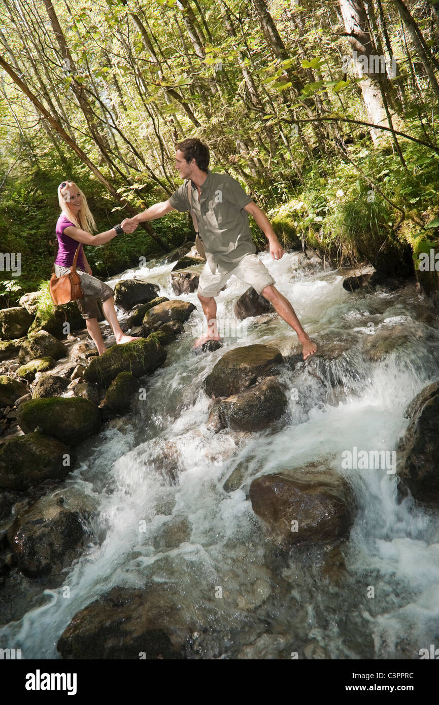Help Cross Stream Austria, Steiermark, Man helping woman to cross stream, holding hands ...