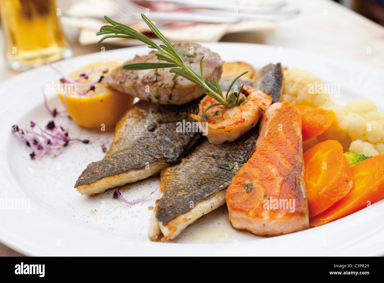 Fishes in plate garnished with vegetable and lemon Stock Photo - Alamy