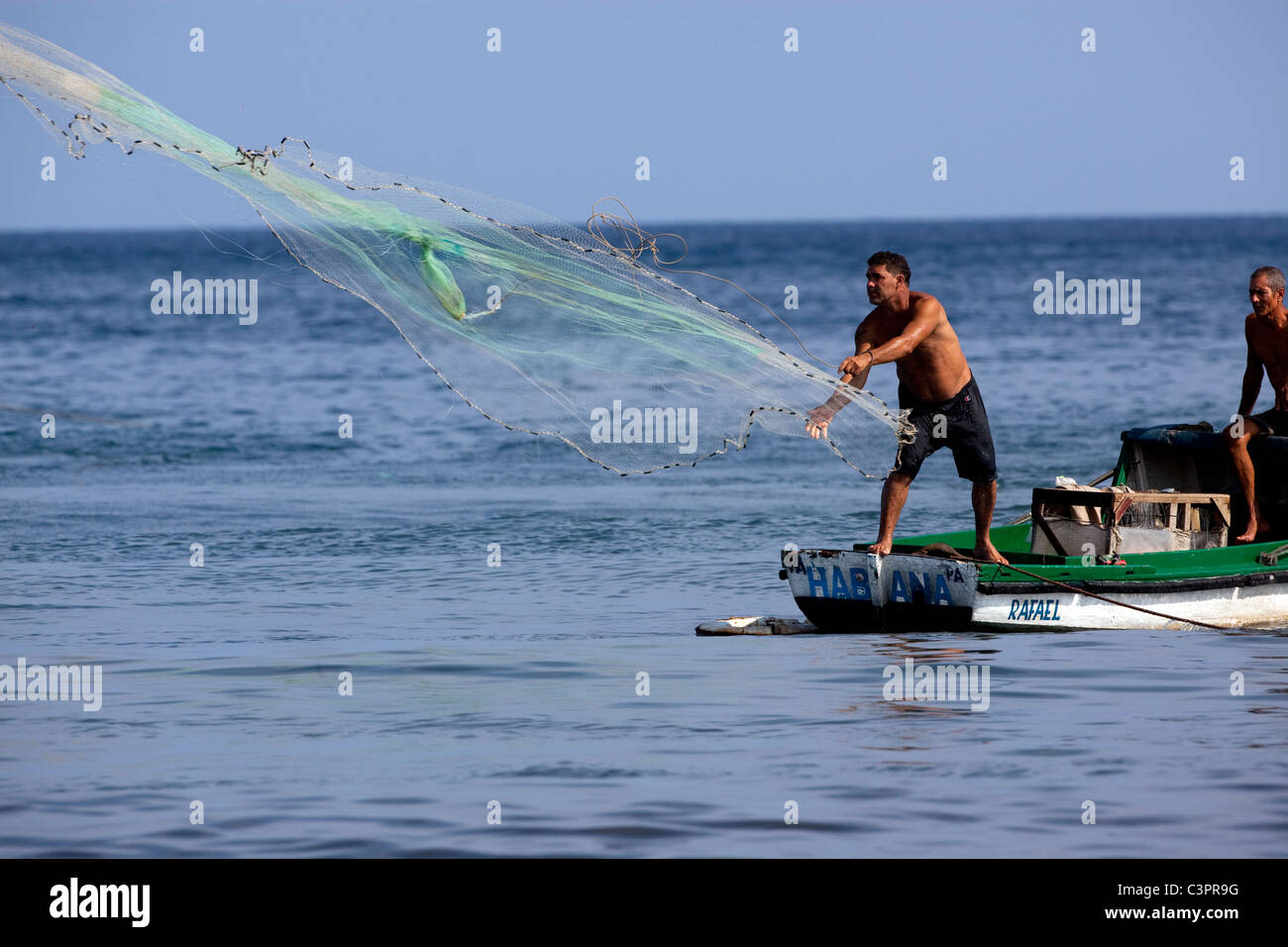 A fisherman casts off his net off the coast of Cuba. Stock Photo