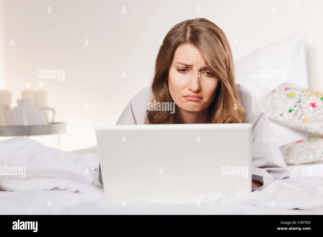 Woman lying on bed with laptop Stock Photo - Alamy