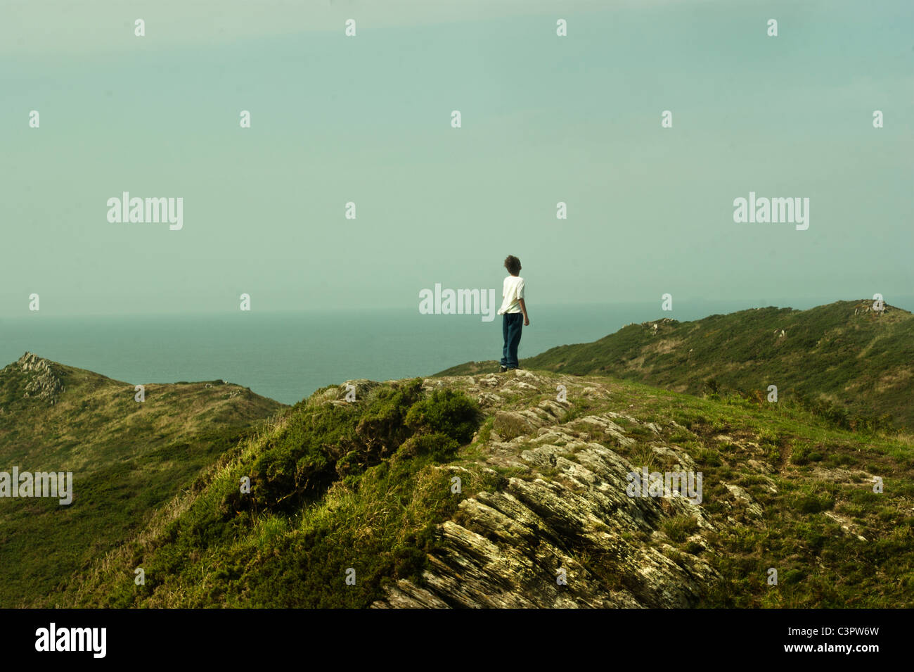 Young boy looks out to see on the cliffs of Mortahoe, North Devon, Stock Photo